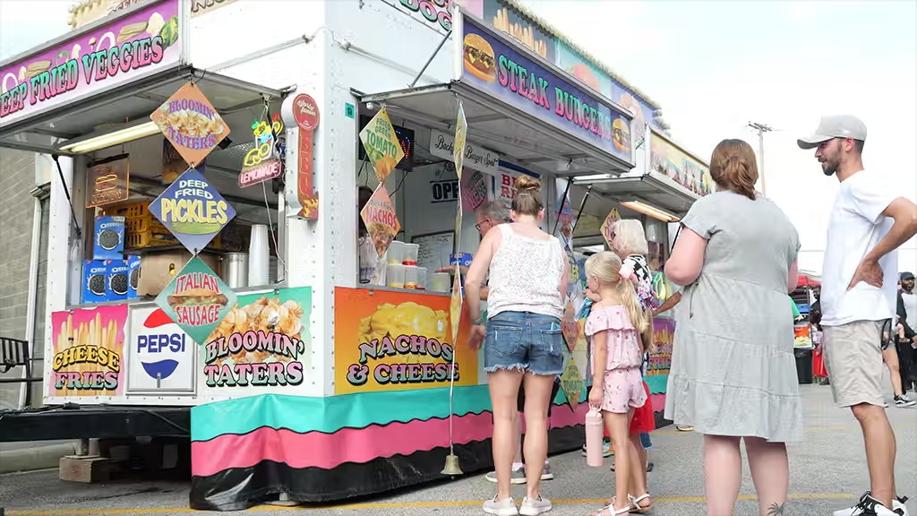 A festival food vendor serving families
